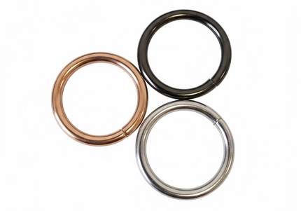 Three metal rings of different colors on a light gray background