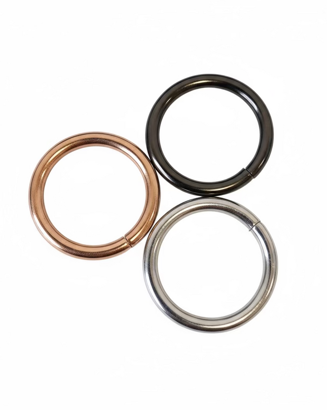 Three metal rings of different colors on a light gray background