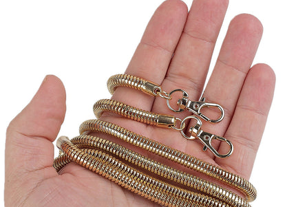 Gold chain with clasp held in a hand against a white background